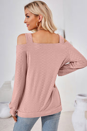 Blush pink textured blouse with cutout shoulders and square neckline.