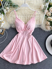Pink V-neck spaghetti strap mini dress with adjustable straps and a flowy skirt.