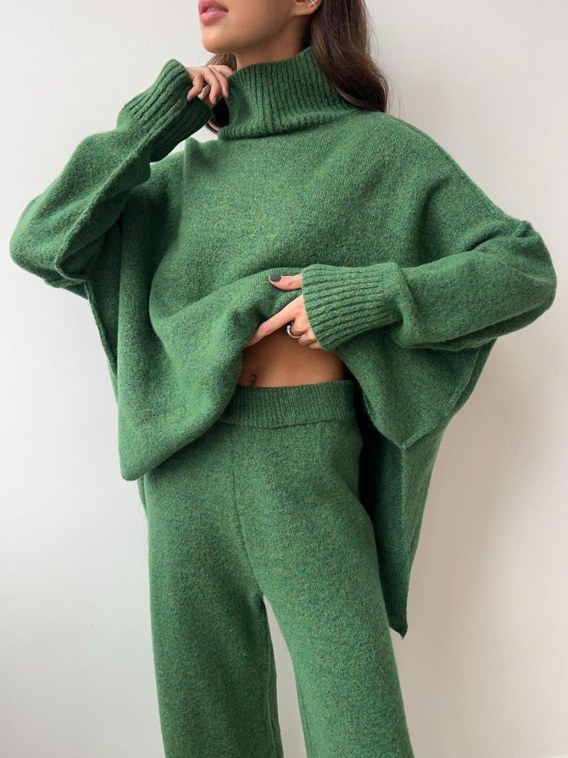 Oversized green acrylic turtleneck lounge set with wide sleeves and matching pants.