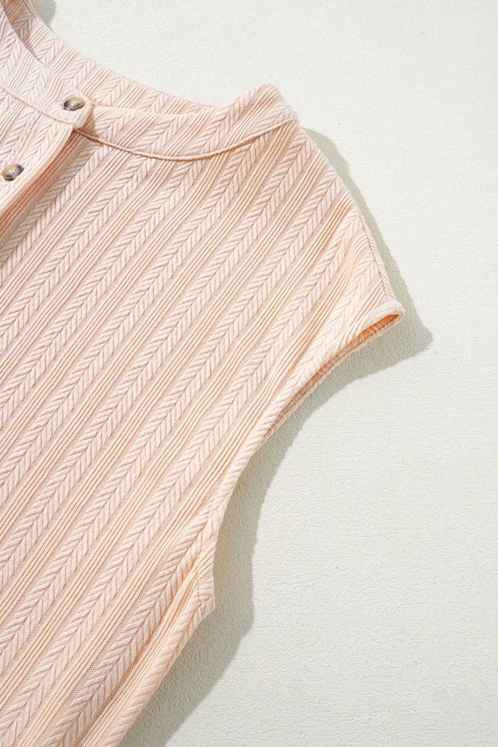 Textured ribbed sleeveless collar jumpsuit in eggshell with button detail.