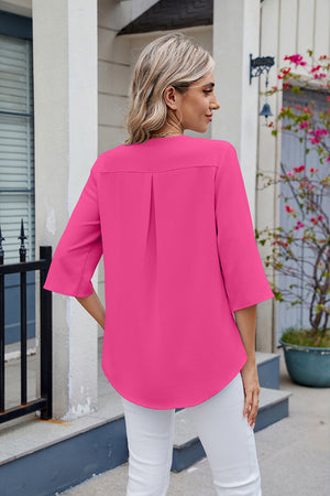 Hot pink V-neck flutter sleeve blouse with back pleats and curved hem.