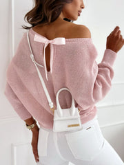 Blush pink off-shoulder batwing knit sweater with a bow-back detail.