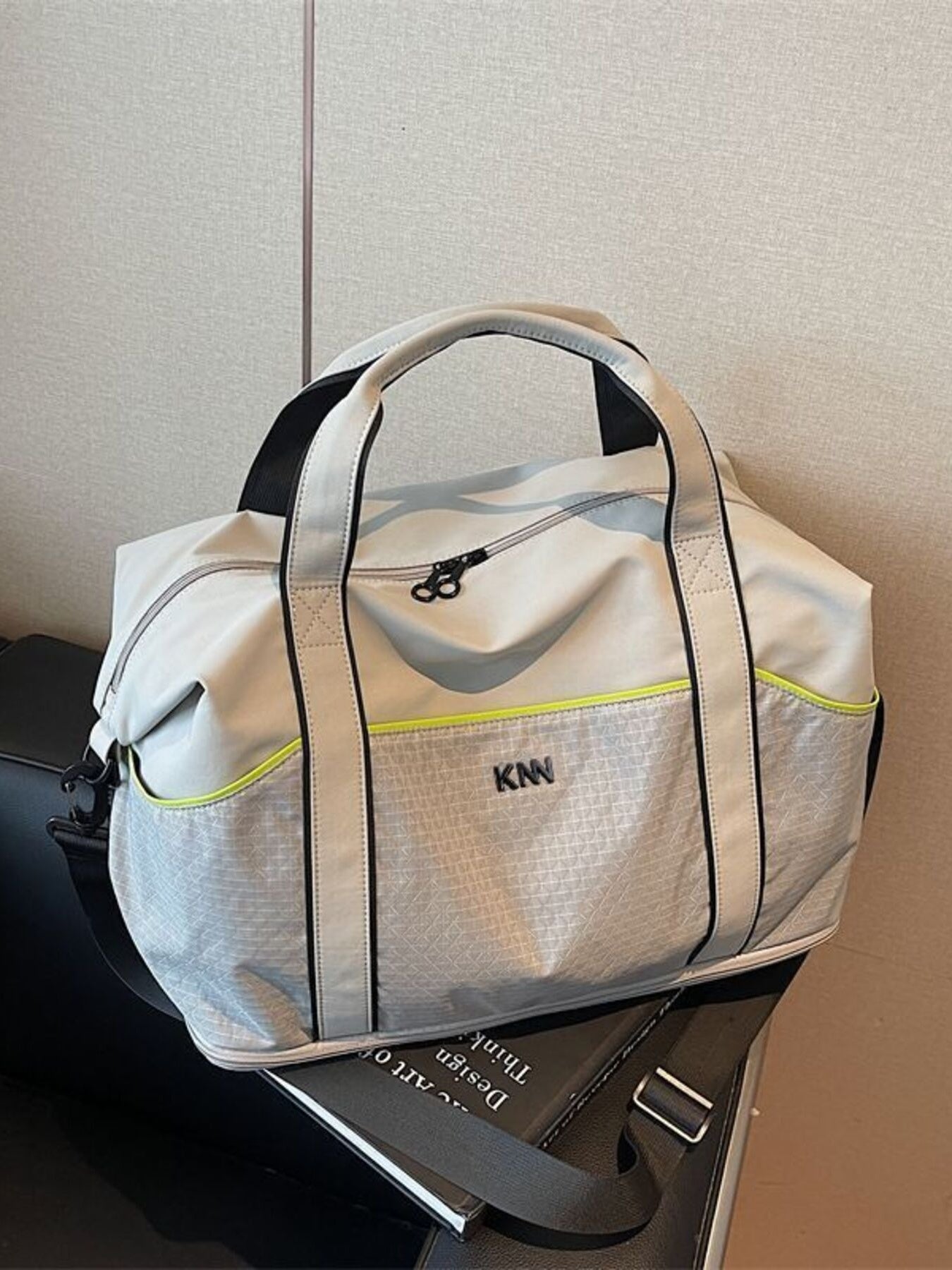 Large gray nylon duffel bag with grid pattern, black trim, and neon yellow accent.