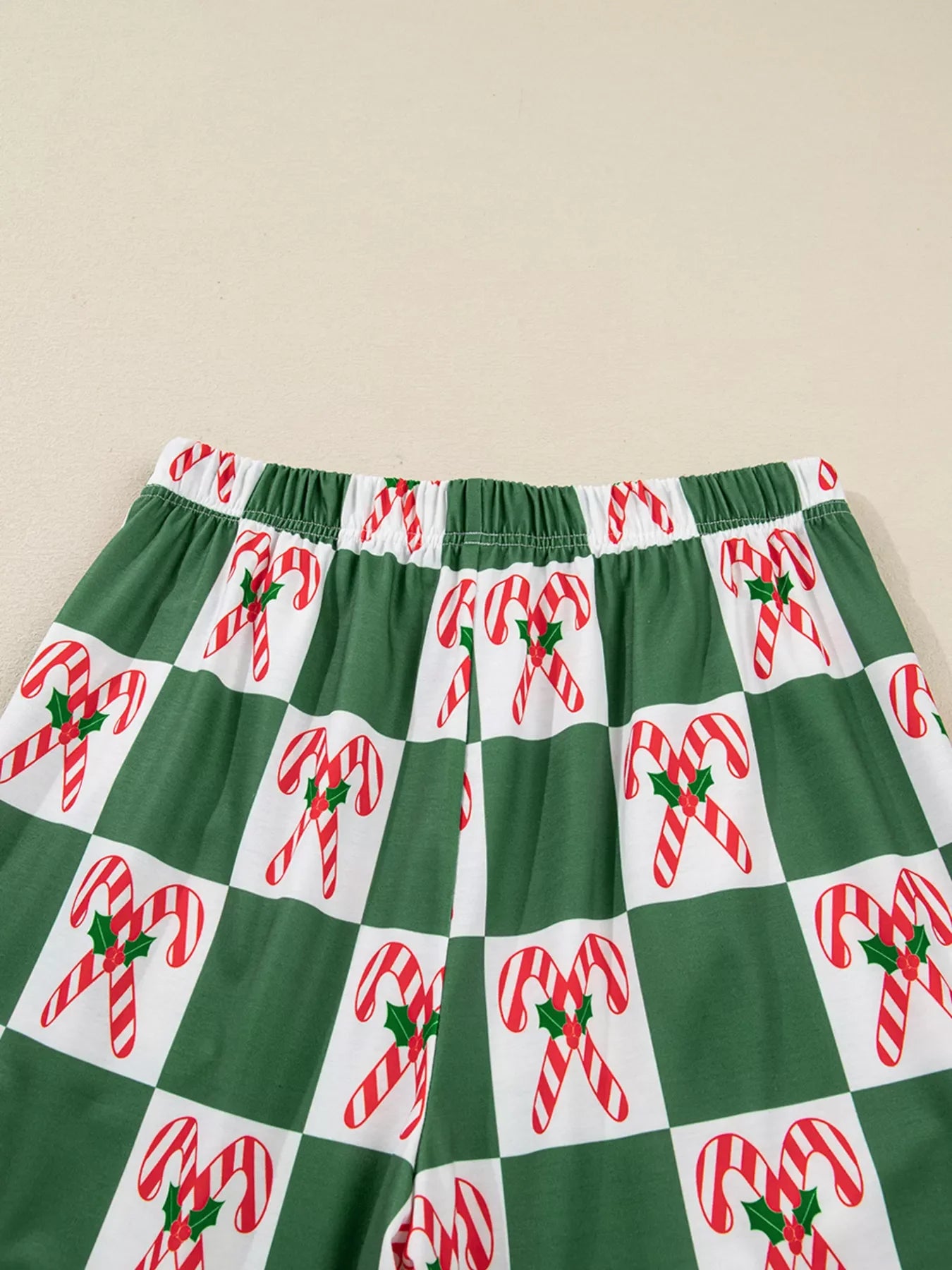 Green pajama pants with a candy cane checkered print and elastic waistband.