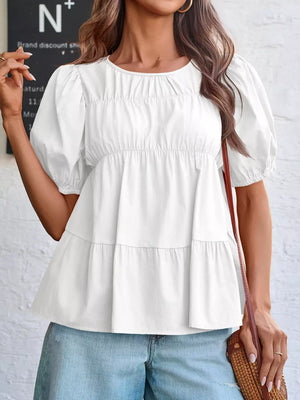 White maternity blouse with puff sleeves, ruffled neckline, and tiered hem