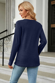 Dark blue waffle knit long sleeve top with crew neck, styled with jeans.