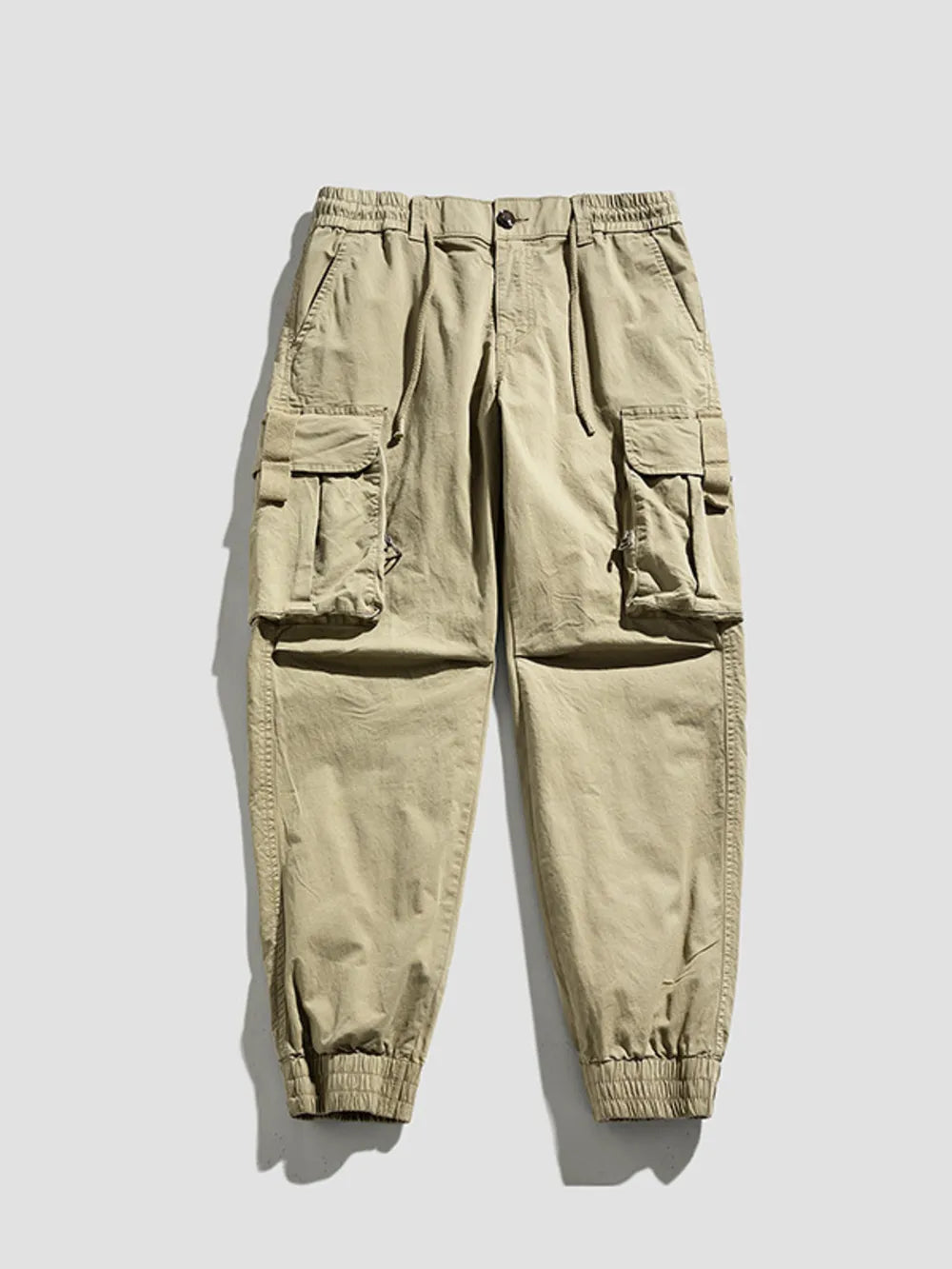 Khaki cargo joggers with flap pockets and elastic cuffs.