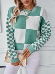 Checkerboard knit sweater in turquoise and white with crew neck and long sleeves.