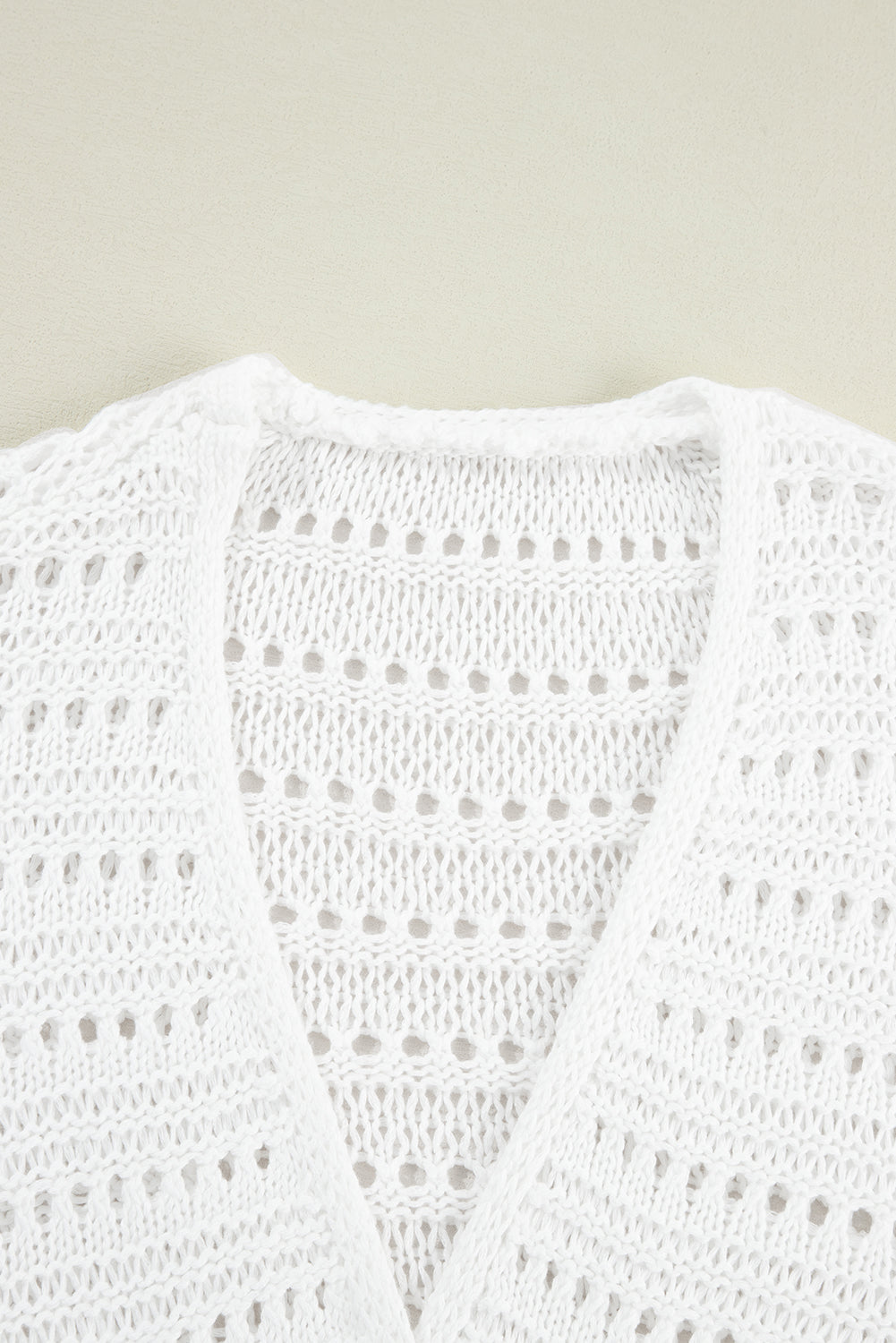 White open-knit dolman sleeve cardigan with a V-neck and breathable acrylic fabric.