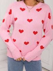 Pink acrylic knit sweater with a red heart print, crew neck, and long sleeves.