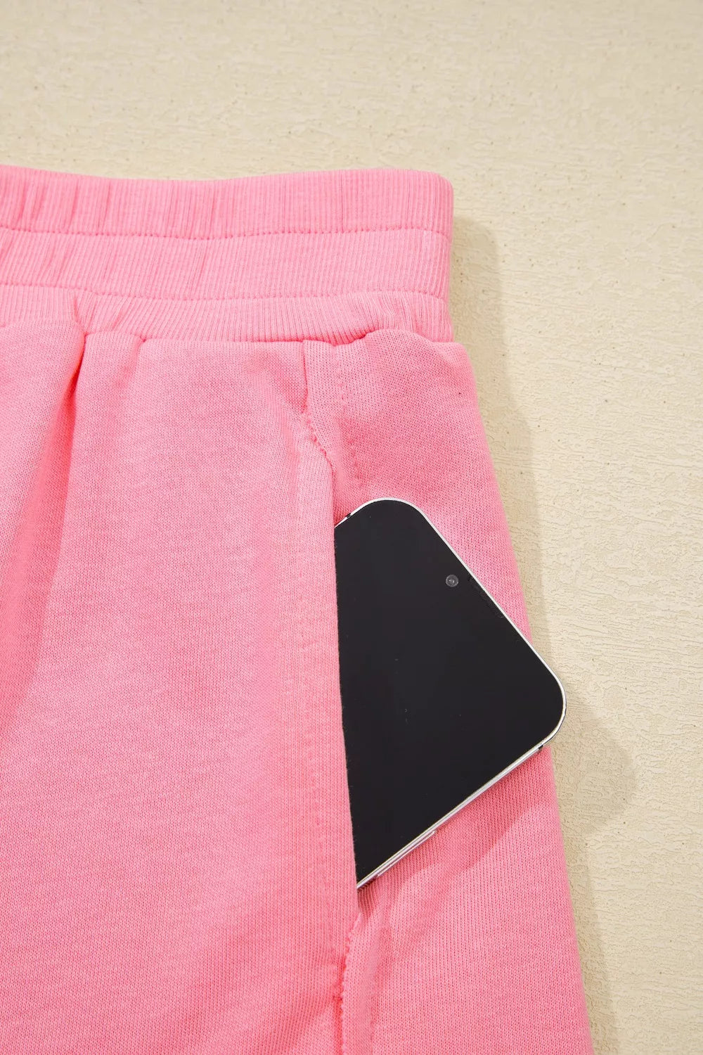 Dusty pink pocketed skort with elastic waistband and phone detail.
