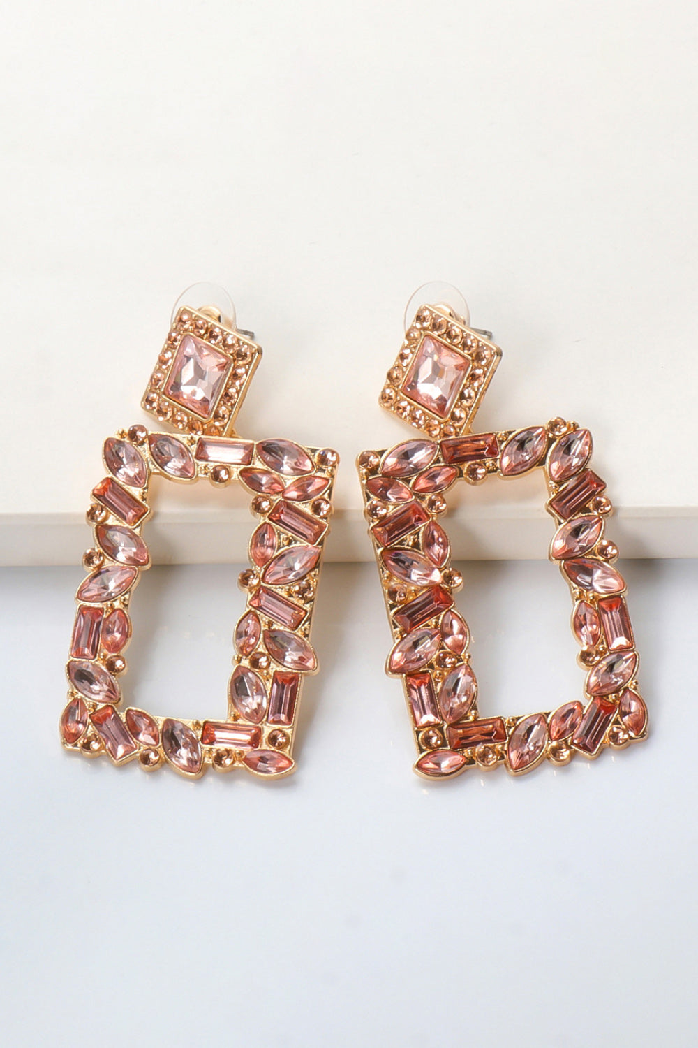 Geometric jewel box earrings with pink rhinestones and gold alloy setting.