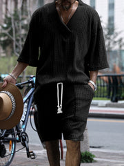 Black cable-knit v-neck two-piece set with drawstring shorts and short sleeves.