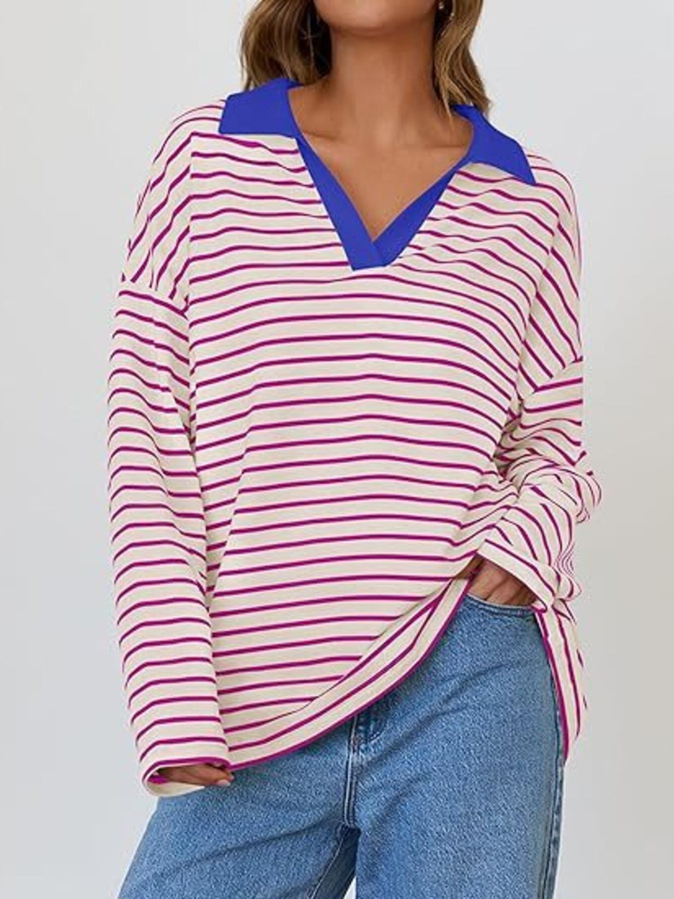 Oversized striped long-sleeve sweatshirt with a blue collar and v-neck, in cream with magenta stripes.
