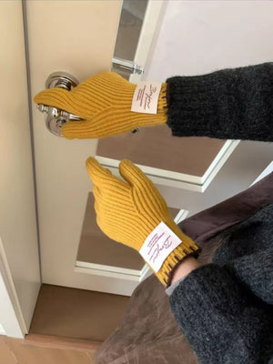 Yellow ribbed knit gloves with scalloped cuff detail and a white tag.