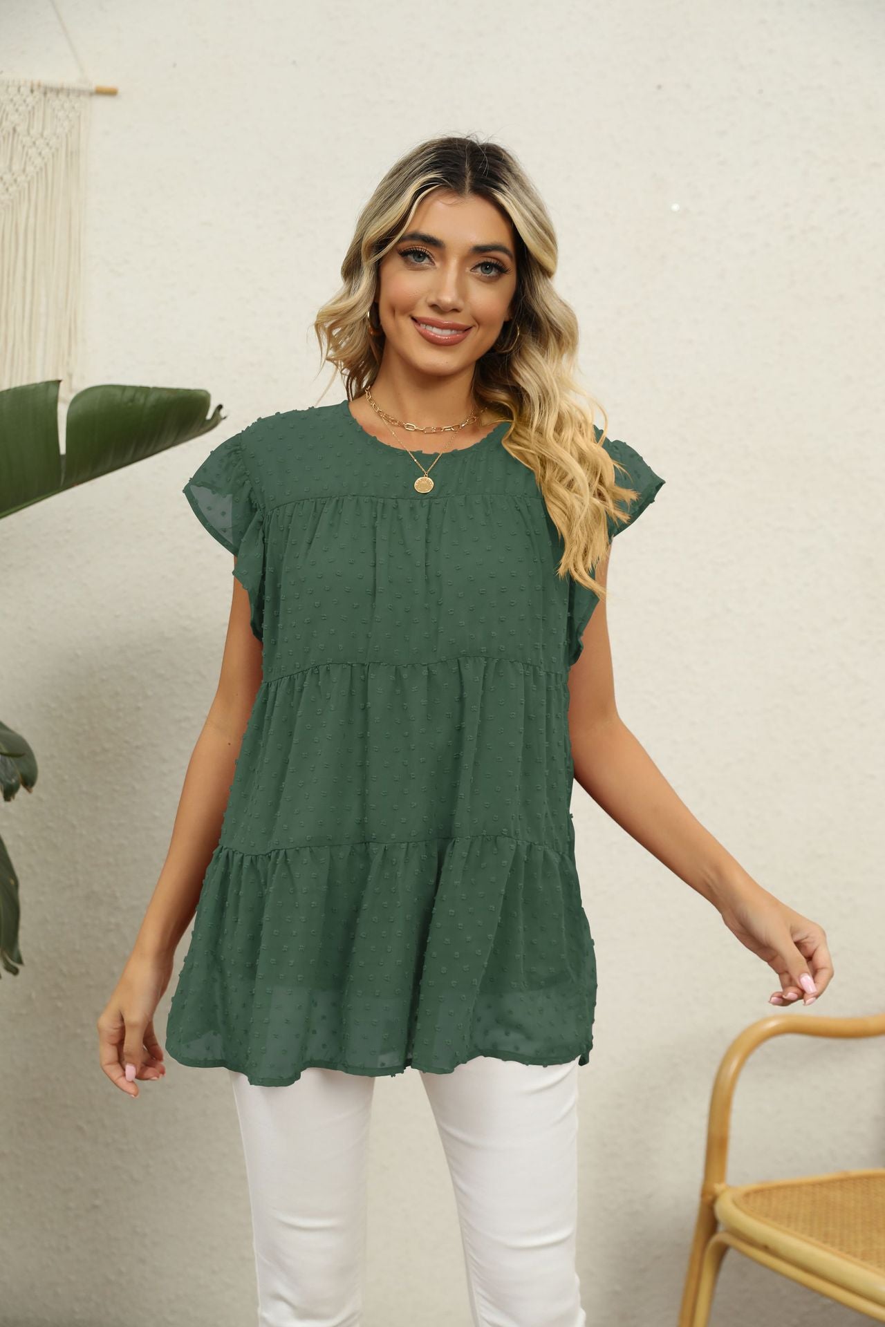 Forest green Swiss dot tiered blouse with flutter sleeves and round neckline.