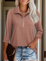 Textured zip-front polo top in dusty pink with a ring zipper detail and rolled sleeves.