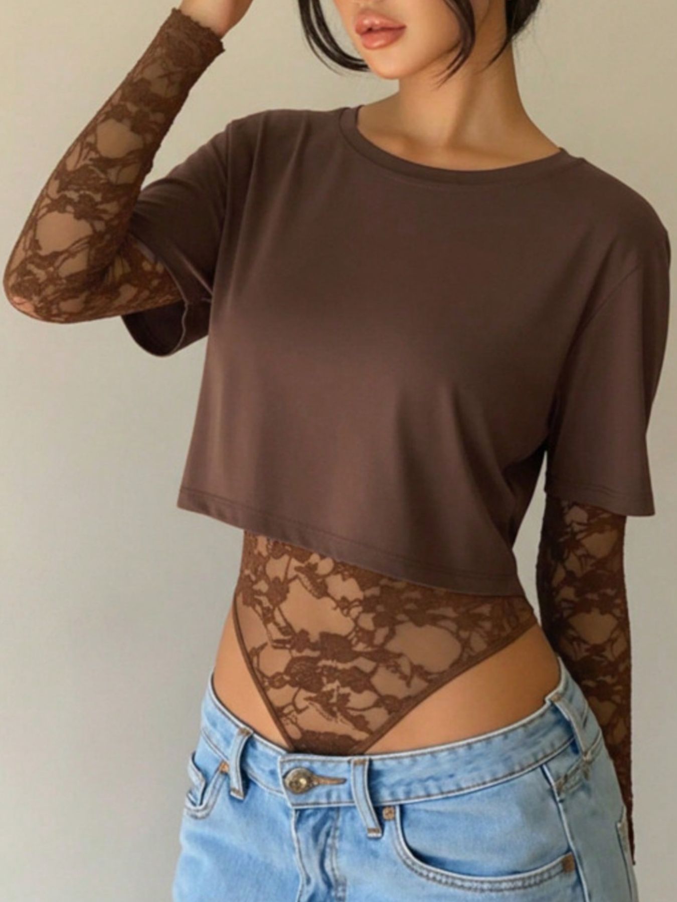 Brown lace bodysuit with sheer long sleeves and a cropped top overlay.
