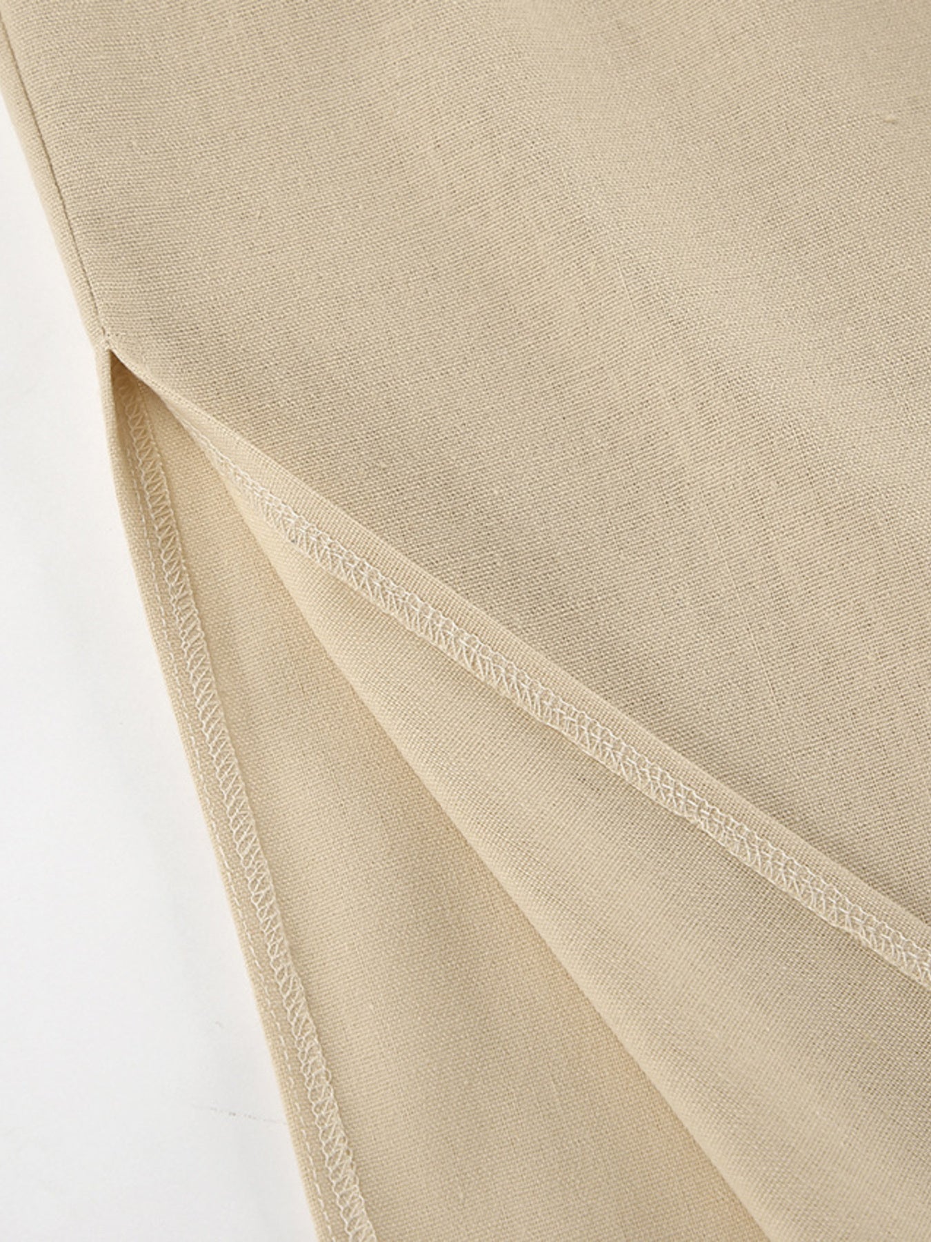 Tan cotton crop top and wide-leg pants set detail showing side slit and stitching.