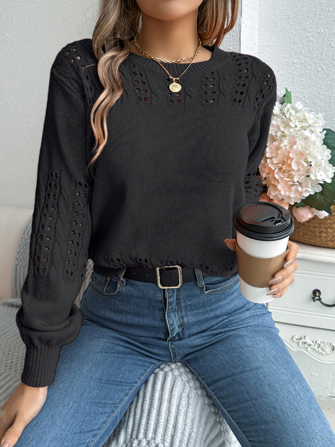 Black openwork knit sweater with crew neck and long sleeves.