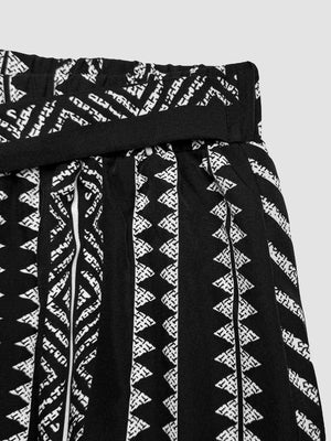 Black maternity pants with white geometric print and adjustable waist detail.