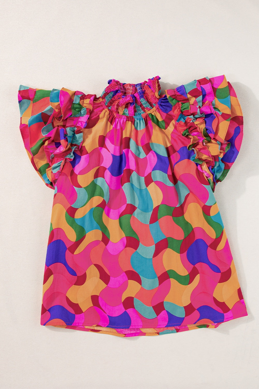 Kaleidoscope ruffle sleeve smocked blouse in hot pink with a colorful abstract wavy pattern.
