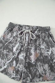 Maple leaf print elastic waist shorts with drawstring in abstract camouflage pattern.