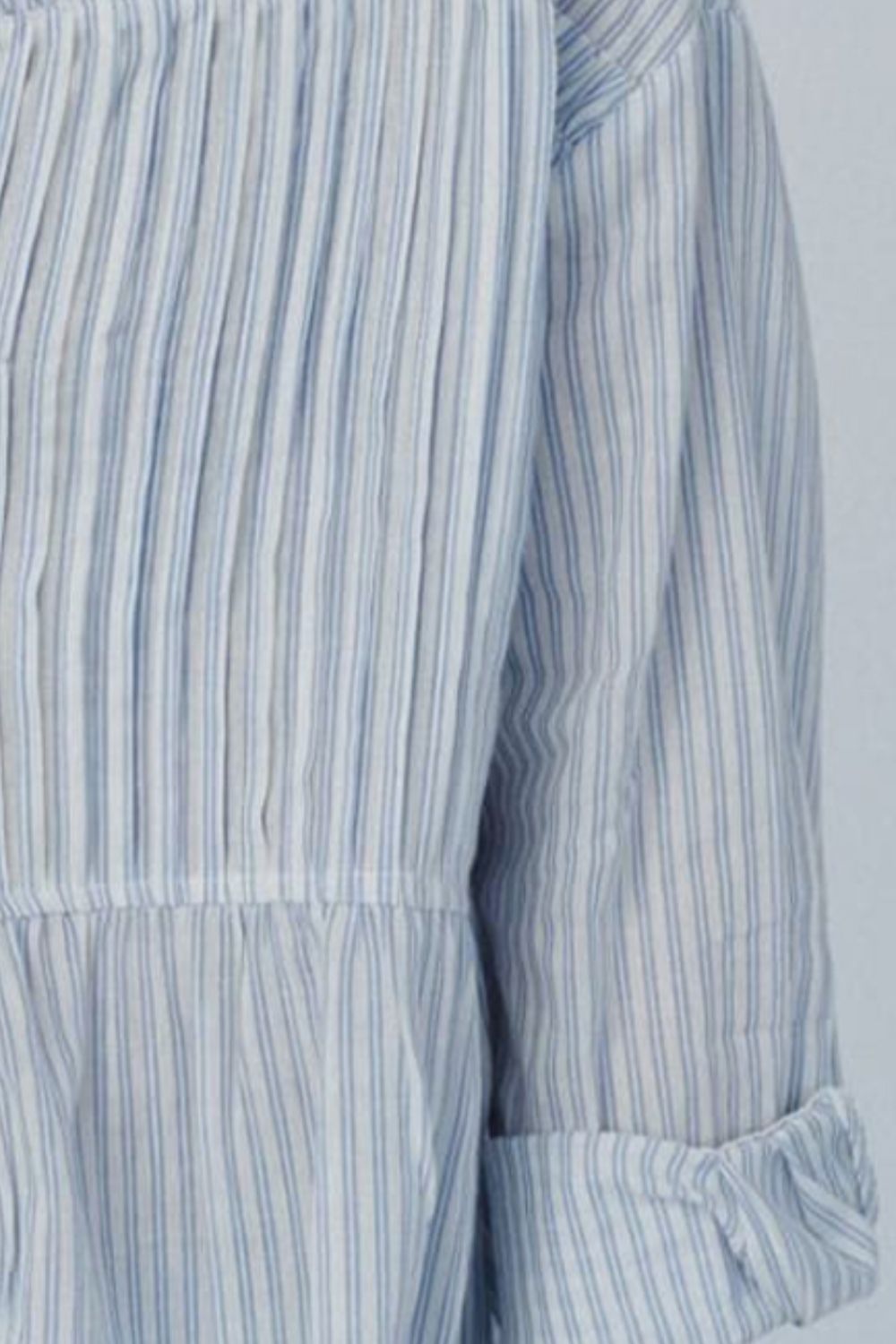 Light blue and white striped peplum blouse with pleats and cinched waist detail.