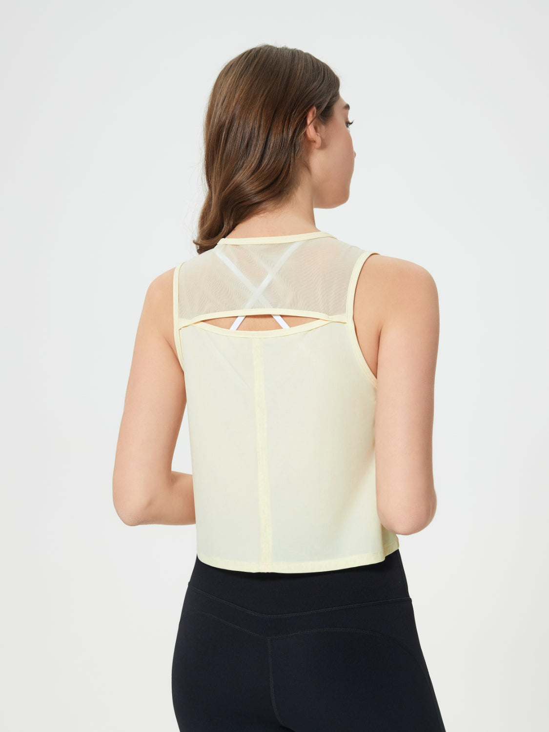 Pastel Yellow cropped active tank with mesh back detail and white bra straps visible.