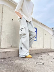 Grey cargo sweatpants with adjustable drawstring details and multiple pockets.