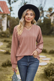 Textured cable knit v-neck sweater in dusty pink with long sleeves.