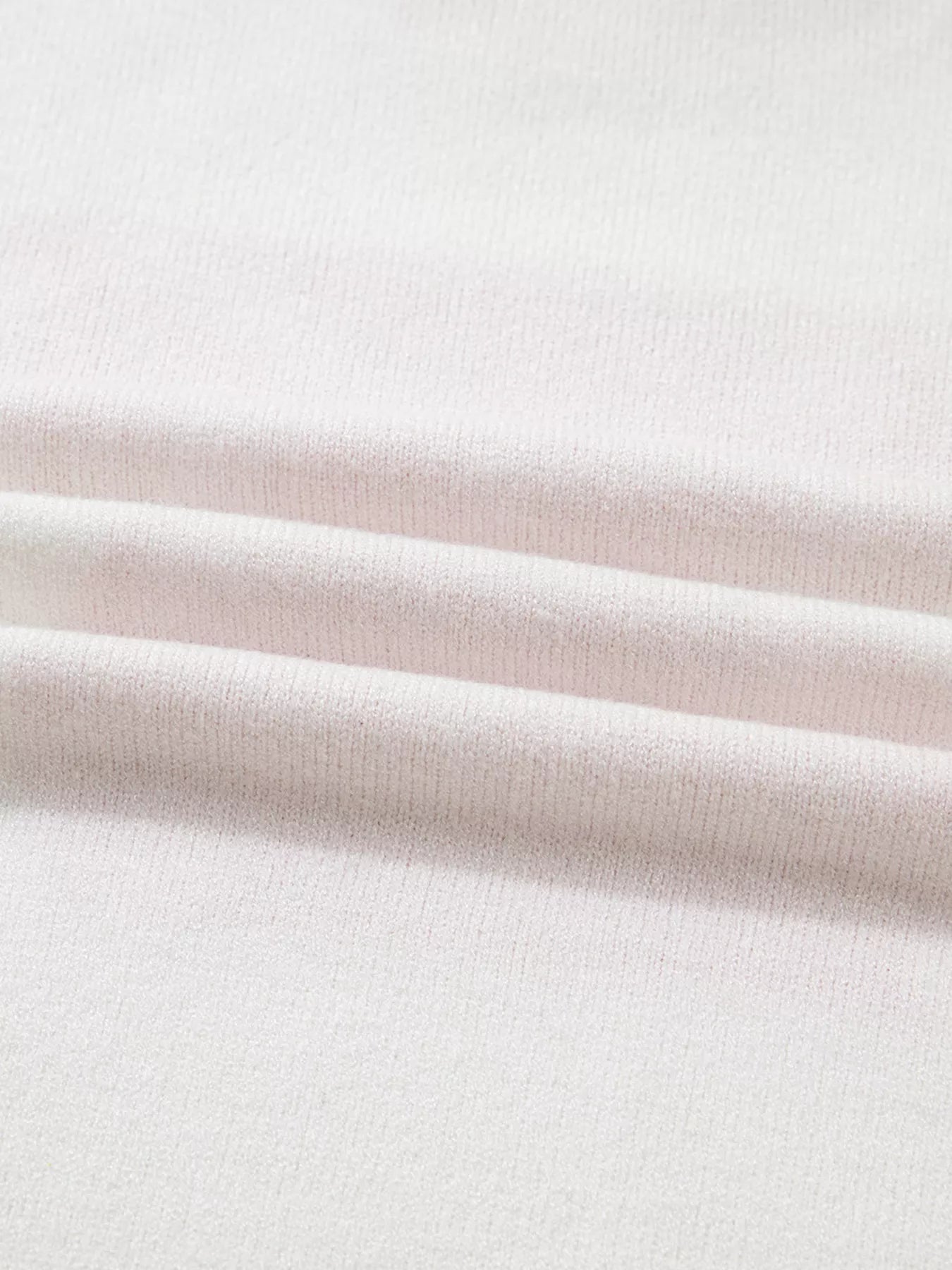 White knit sweater with a textured fabric detail