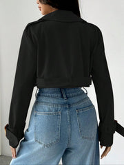 Black cropped double-breasted trench coat with belted waist and adjustable cuffs.