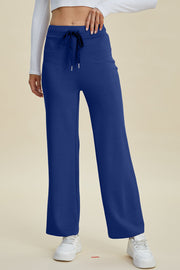 Blue wide leg lounge pants with drawstring waist and white sneakers