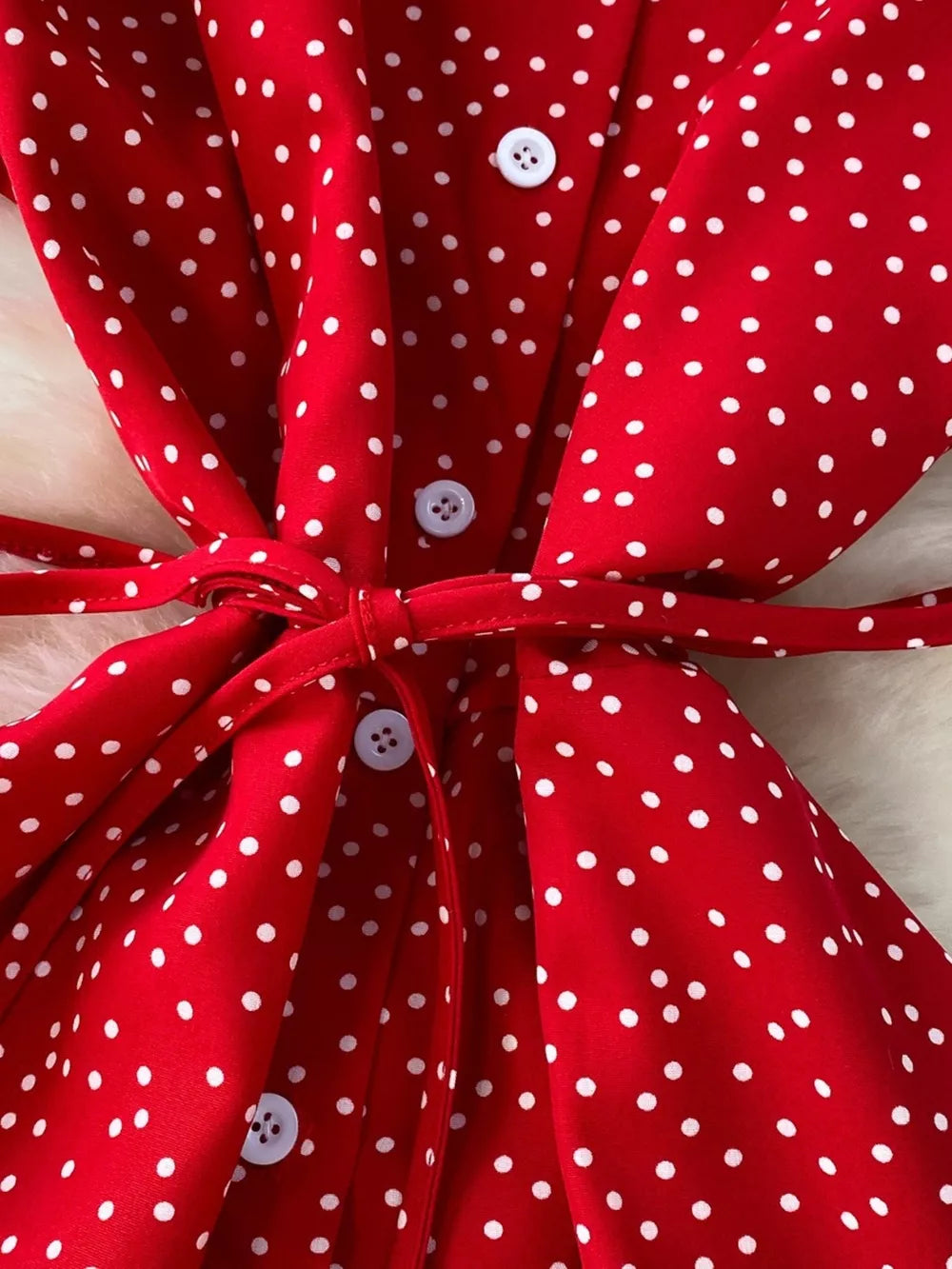Red polka dot maxi dress with white buttons and a tie belt.
