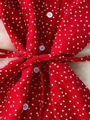 Red polka dot maxi dress with white buttons and a tie belt.