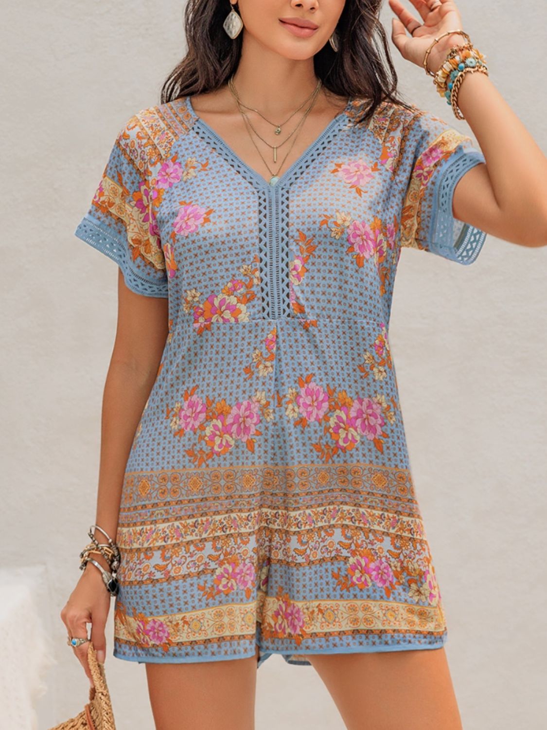 Light blue floral embroidered romper with V-neck and short sleeves