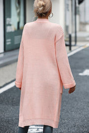 Longline knit cardigan in watermelon pink with pockets and cuffed sleeves.
