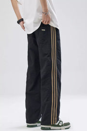 Black relaxed fit sweatpants with tan side stripes and a small logo detail.