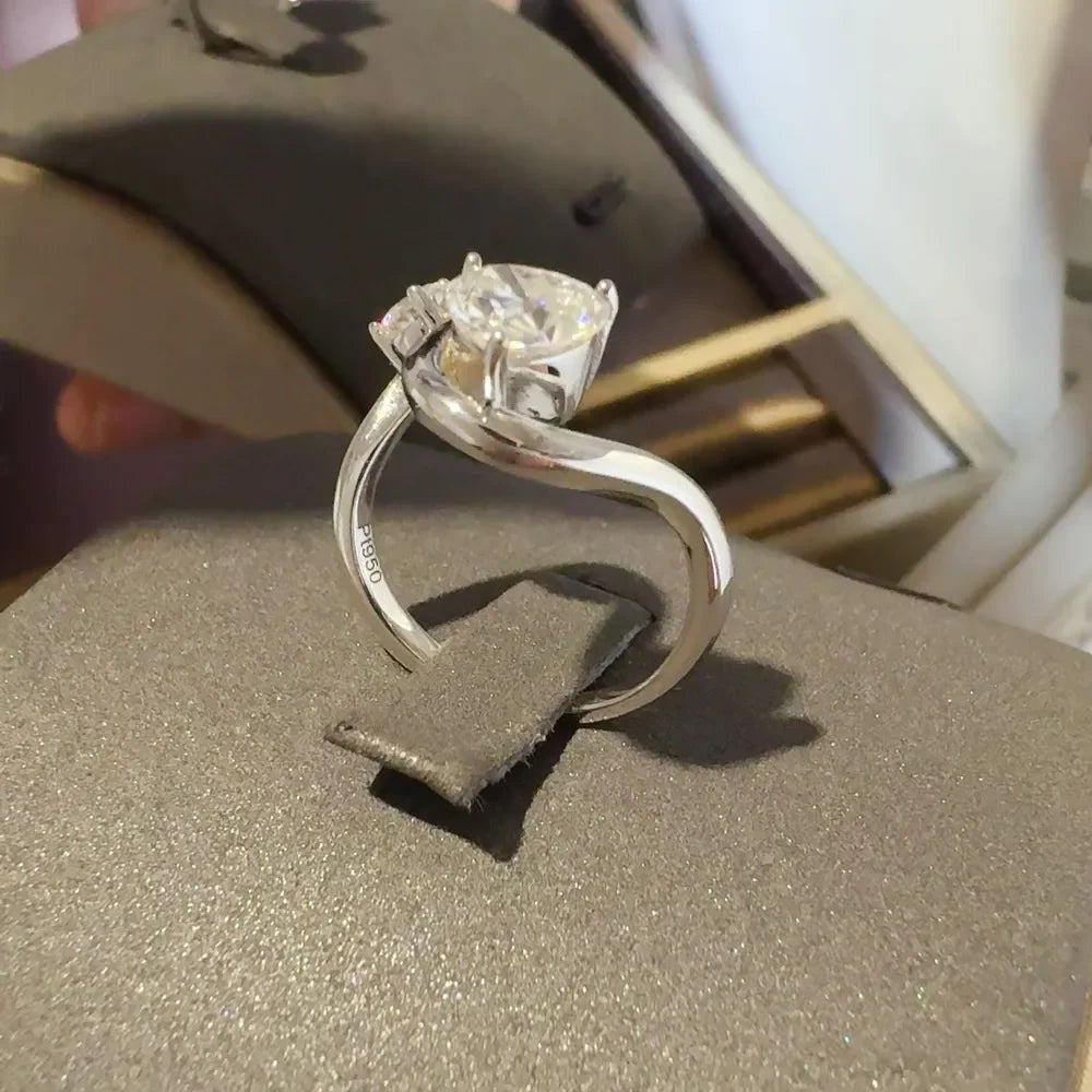 Silver infinity ring with a heart-cut diamond and two accent stones.