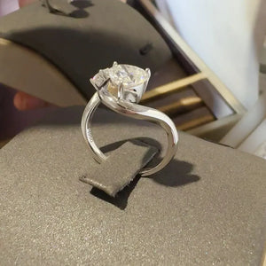 Silver infinity ring with a heart-cut diamond and two accent stones.