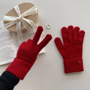 Luxurious wool knit gloves in deep red with ribbed cuffs and a small oval detail.