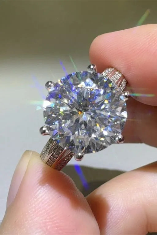 Silver moissanite ring with large round cut center stone and pavé band.