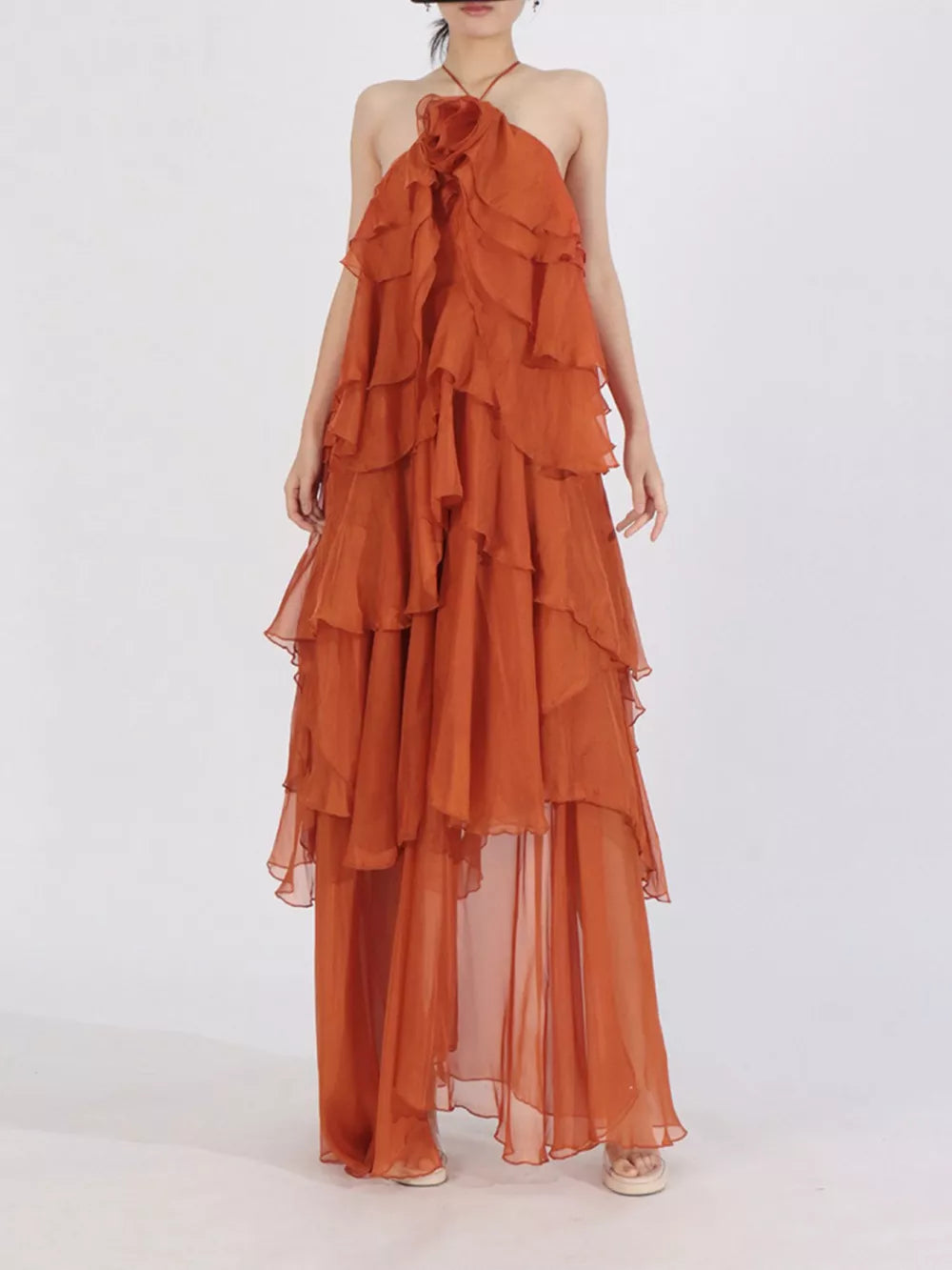 Orange ruffle halter maxi dress with floral detail and tiered skirt.