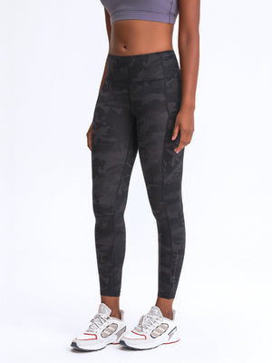 Green camouflage performance leggings with pockets and reflective detail.