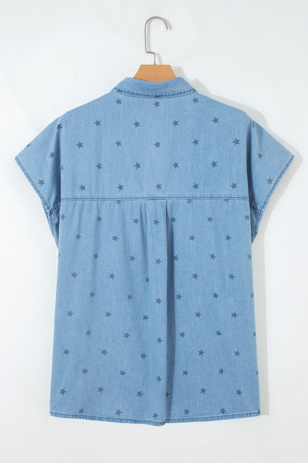 Light blue denim shirt with allover dark star print, short sleeves, and button-down style.