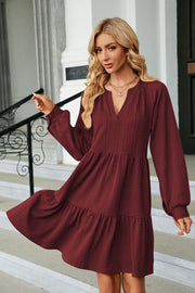 Burgundy textured babydoll mini dress with voluminous sleeves and tiered hem