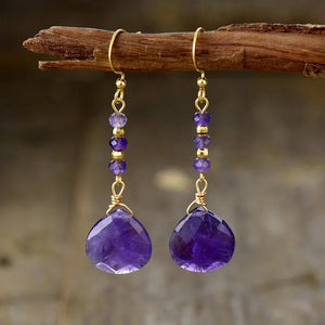 Facet drop amethyst gemstone earrings with gold-plated beads and hooks.