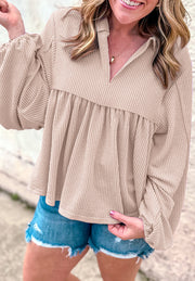 Beige textured blouse with gathered yoke, collar, and balloon sleeves.