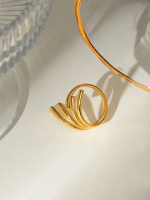 Gold sculptural spiral ring with multiple bands and a modern design.
